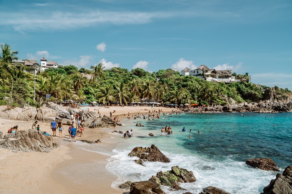 People swimming at a beach in Puerto Escondido, Mexico