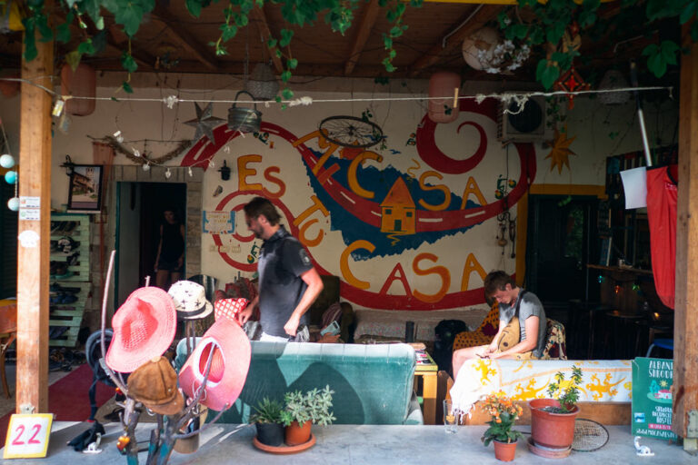 Interior of Shkodra Backpackers’ common area with a colorful mural and guests gathered around a table