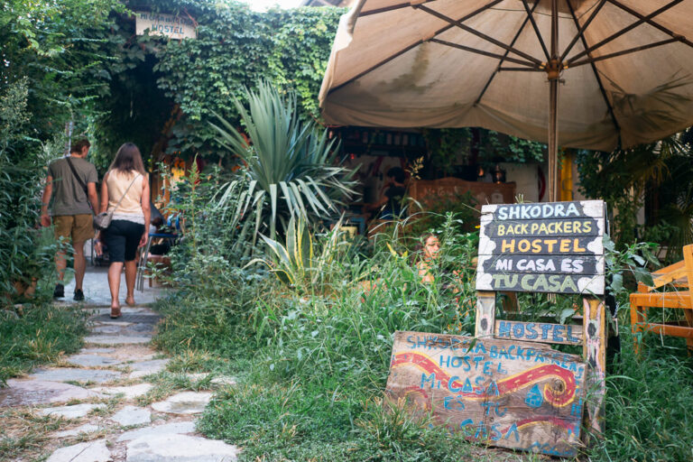 entrance of the Shkodra Backpackers surrounded by a lush garden