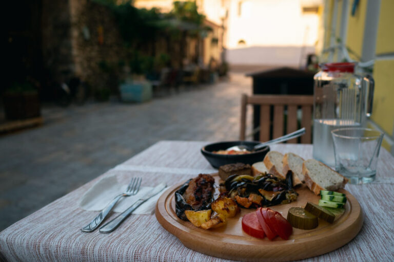 A meal set on a tablecloth at an outdoor café during sunset