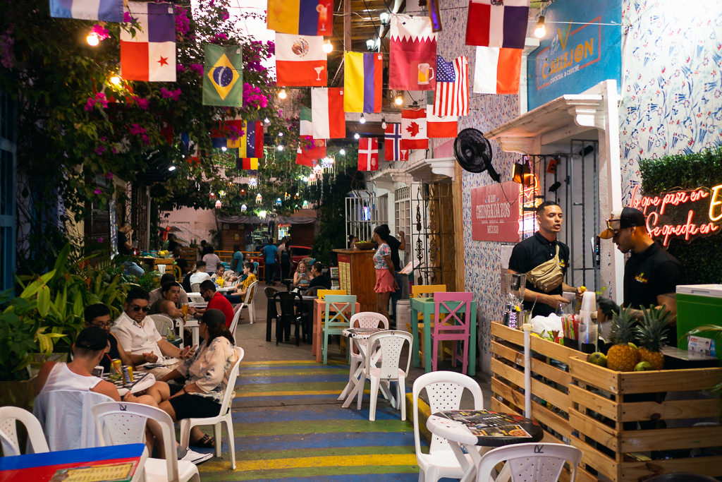 An alley of restaurants with flags of different countries hanging above