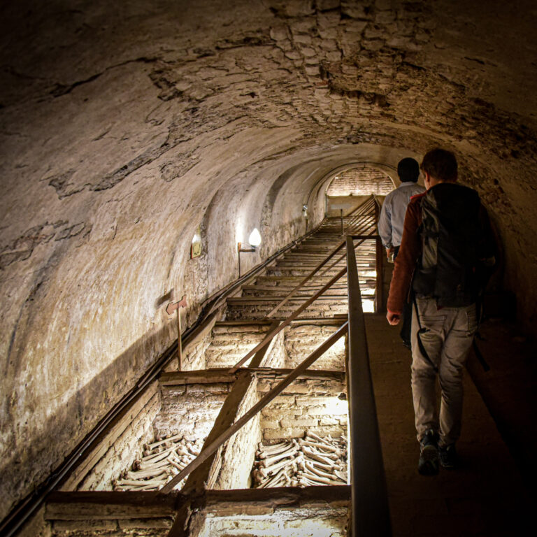 visitors walking through the underground catacombs of the San Francisco Convent