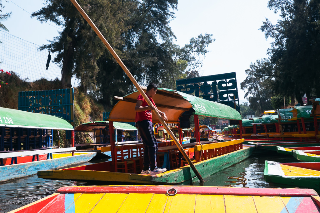 A man pushing a boat with an oar at Xochimilco