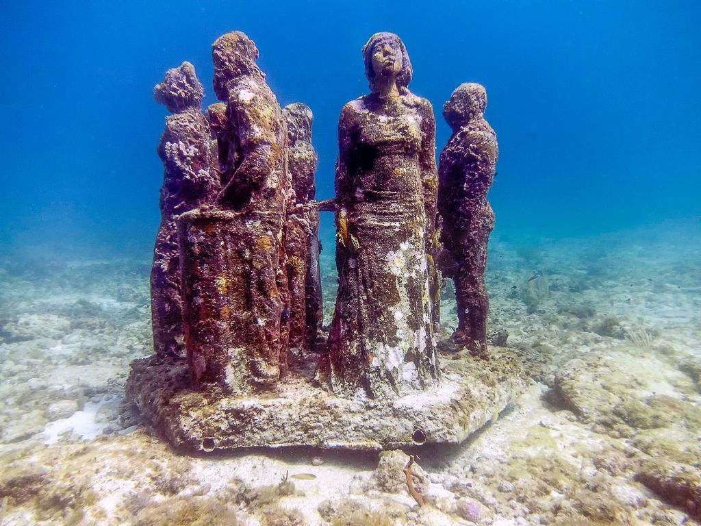 Four human-size sculptures in the Museum of Underwater Art in Isla Mujeres, Mexico