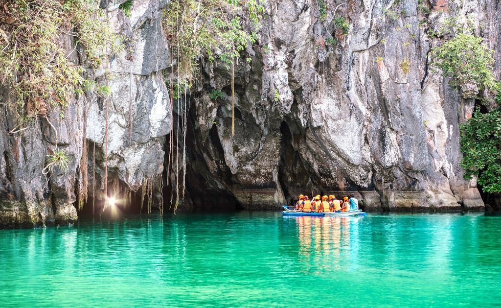 A group of people on a boat at the entrance of the Puerto Princesa Underground River in Palawan, Philippines