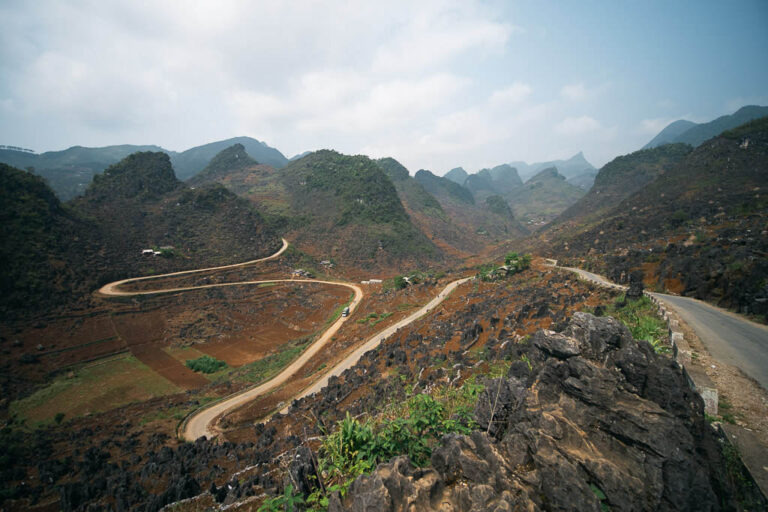 Dong Van Pass in Vietnam with a winding road curving through a mountainous landscape