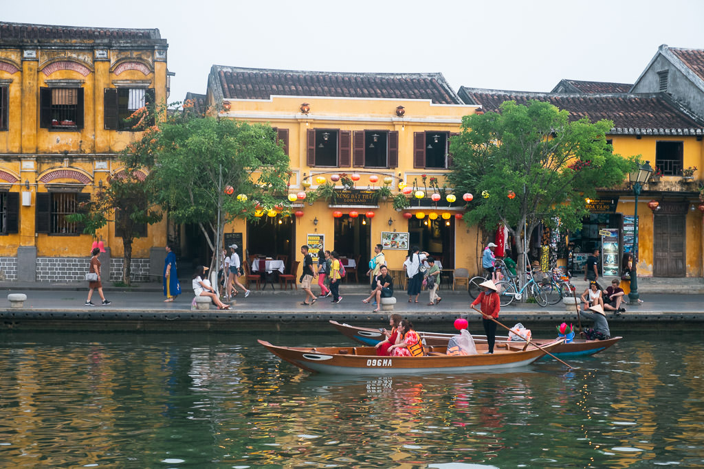 Boat on a river at Hoi An with yellow buildings in the background