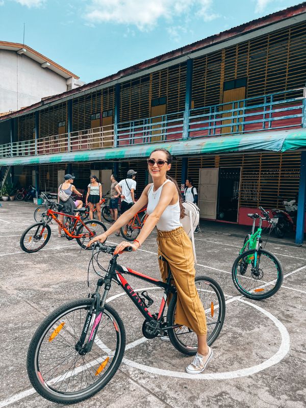 A woman on a biking tour, a Bangkok itinerary must-do.