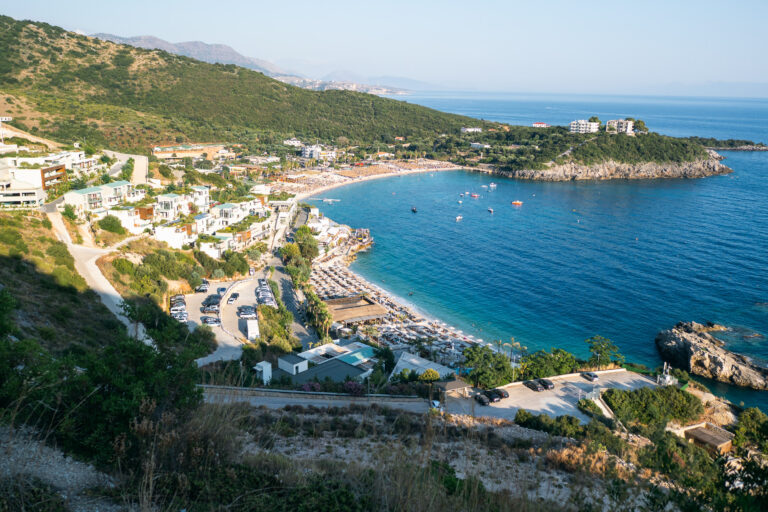 Jala beach near Himara with a crescent pebble beach and white resorts on the hills