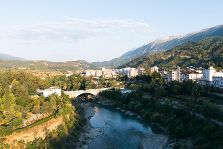 Drone shot of the town of Permet, Albania, showing a bridge over the Vjosa River