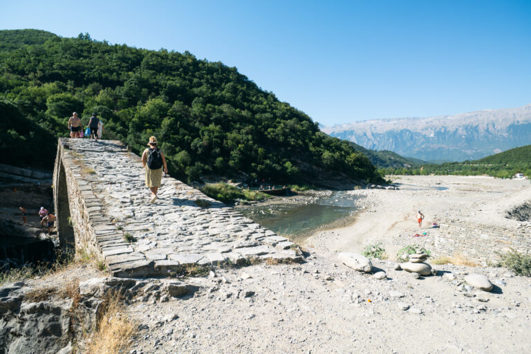 Kadiut Bridge near Përmet, a woman crossing its stone arch