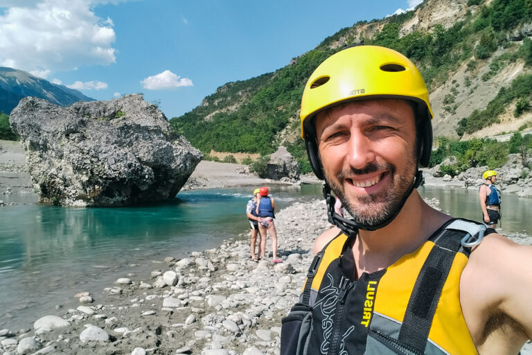 Man (Marek) in rafting gear takes a selfie by the Vjosa River