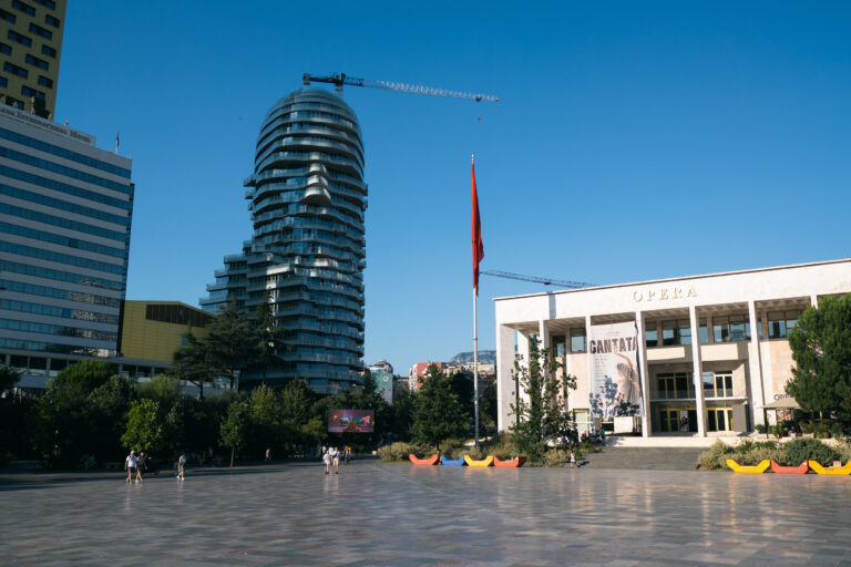 Skanderbeg Square in Tirana with the Opera building, Abania flag, and modern skyscrapers in the background