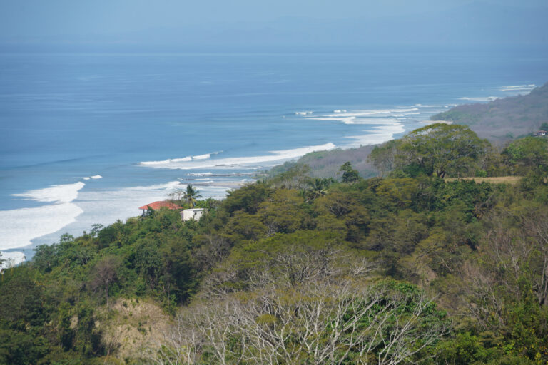 elevated view of the Santa Teresa coastline, with rolling waves and a lush, green landscape