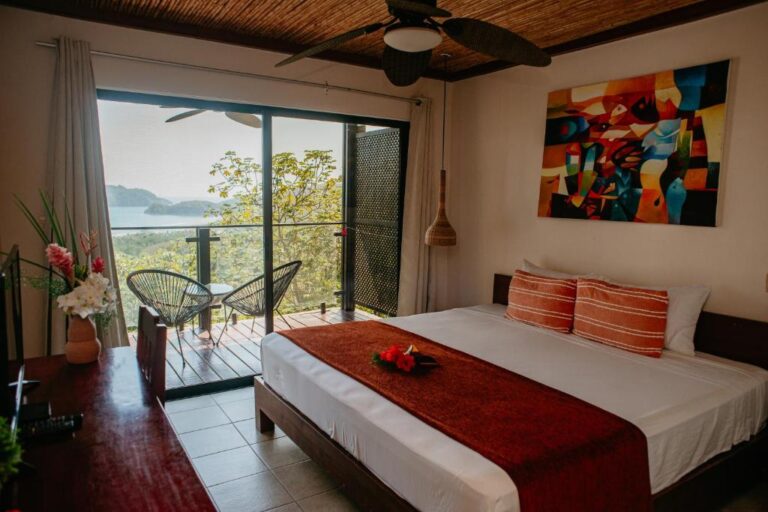 interior view of a bright, tropical king room at Eco Boutique Hotel Vista Las Islas Reserva Natural with a costal view
