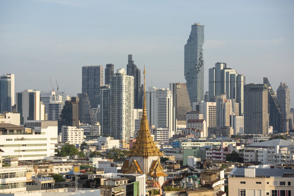 Wat Traimit rising above Bangkok’s dense modern skyline, Thailand