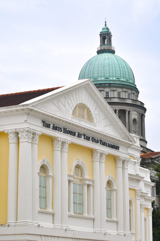 The Arts House at The Old Parliament in Singapore, with the large green dome of the neighboring National Gallery in the background
