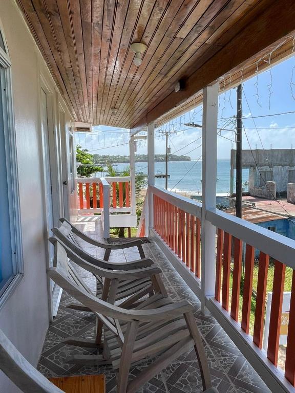 A narrow balcony with wooden rocking chairs overlooking the Sea on Little Corn Island