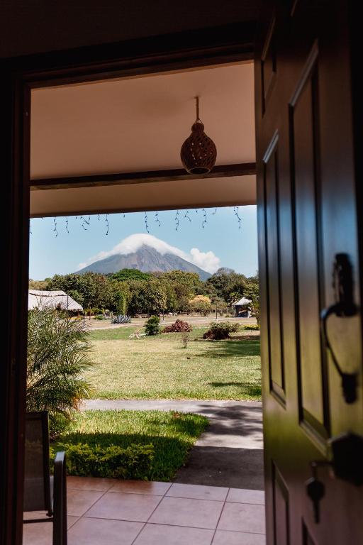 A view framed by an open wood doorway looking out from a patio toward the Concepción Volcano on Ometepe Island