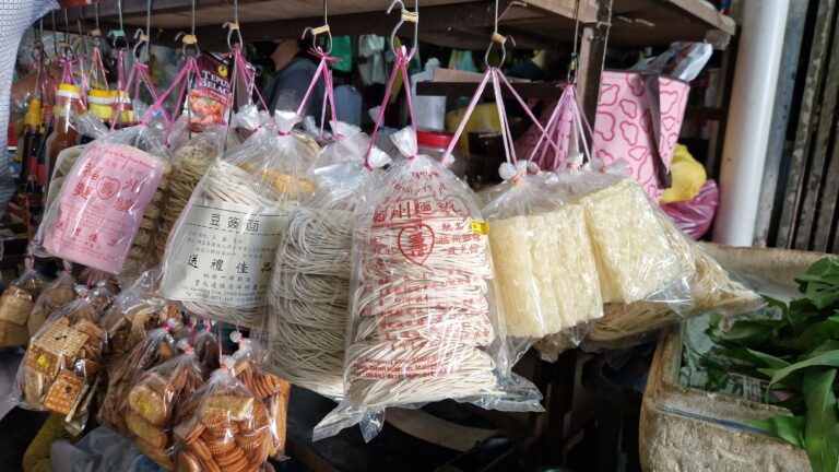 Hanging bags of traditional dried noodles at a market stall in Air Itam, Penang