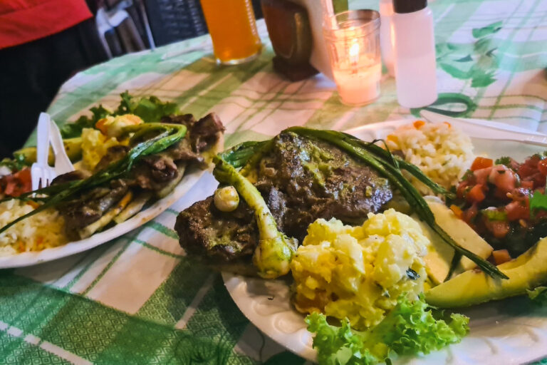 Grilled steak plates with salad, rice, and avocado 