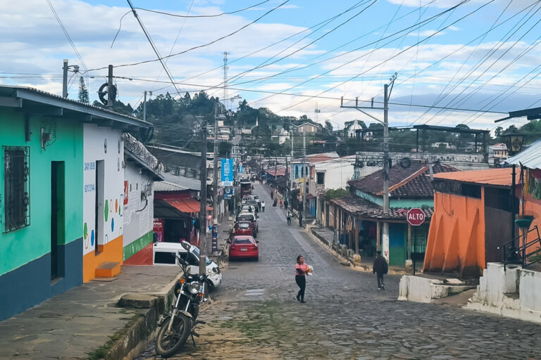 Cobblestone street in Concepción de Ataco featuring buildings and a hills in the background