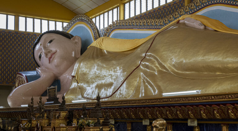 Inside the Wat Chayamangkalaram Thai Buddhist Temple in Pulau Tikus, Penang, showing one of a long reclining Buddha statues