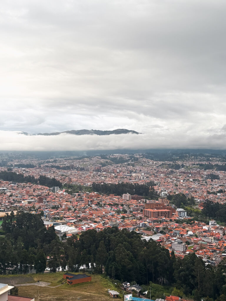 High-angle view of Cuenca from Mirador Turi, with red-tiled roofs with distant mountains
